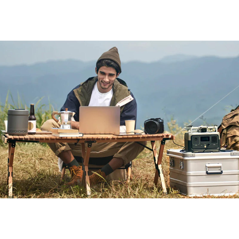 EcoFlow RIVER 2 power station powering laptop and camera during off-grid camping