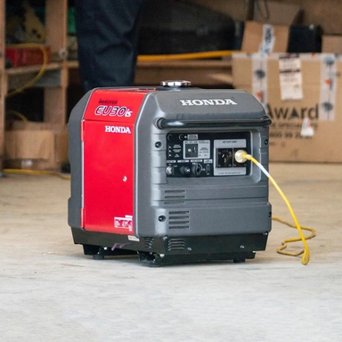 Honda EU30iS inverter generator powering equipment on a worksite with extension lead connected