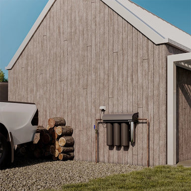 Puretec Hybrid E13 whole house rainwater filtration system installed on exterior wall connected to tank water supply